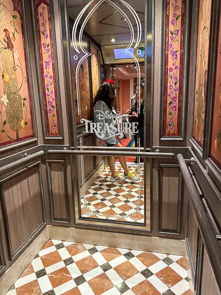 Inside an elevator on Disney Treasure with my reflection in the mirror