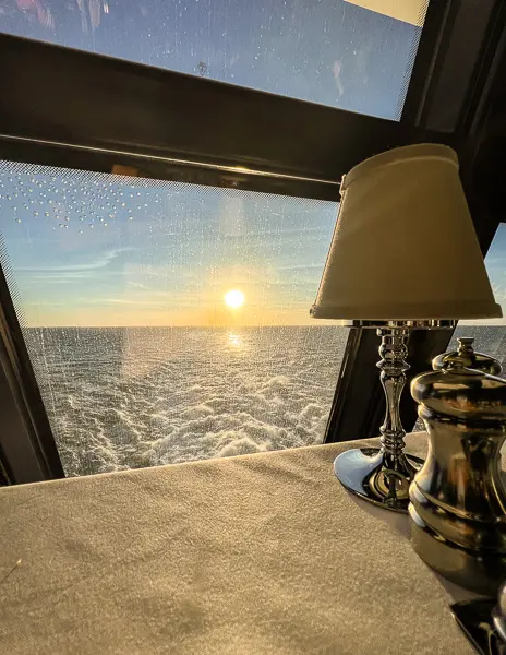 sunset by window by aft of cruise ship