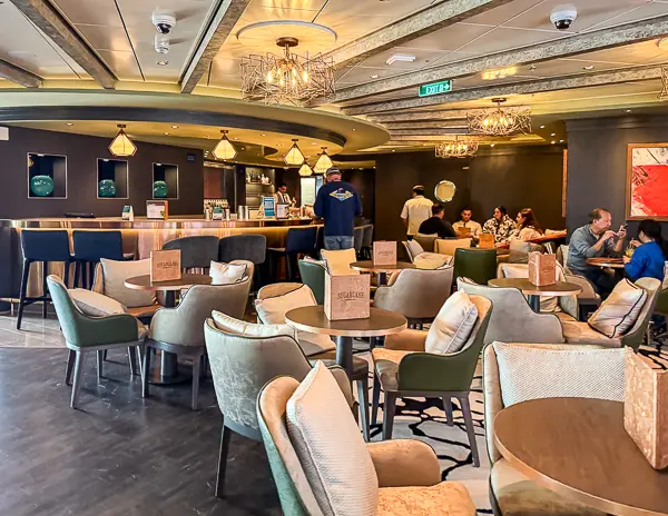 Cruise ship lounge with seating and bar area where passengers relax onboard