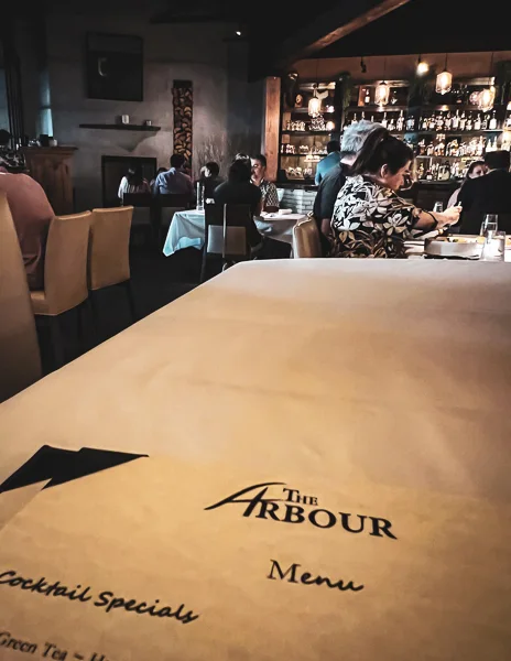 peek of menu title and restaurant from table at the arbour