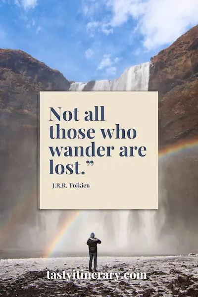 graphic: person stands in front of a tall waterfall with a rainbow curving through the mist. The quote “Not all those who wander are lost.” by J.R.R. Tolkien is centered in a beige text box.