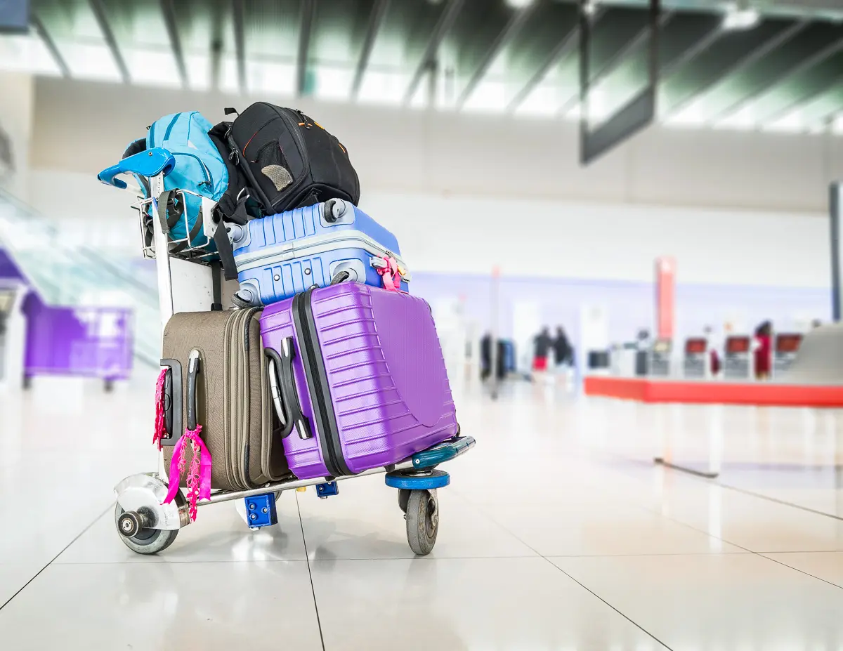 featured blog image | cruise luggage tag holders | luggages stacked on a cart