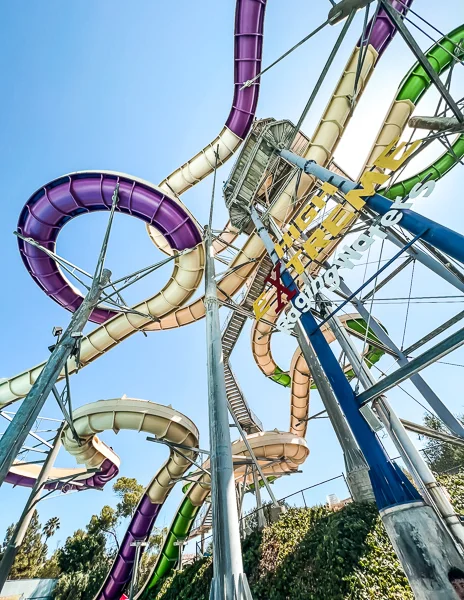 Colorful water slides looping around each other at Raging Waters with a clear blue sky in the background