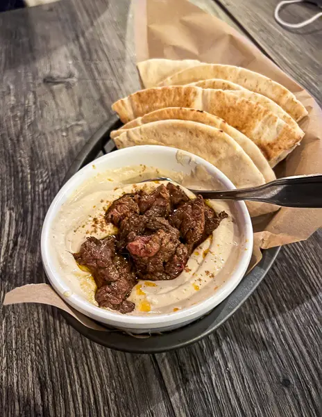 hummus topped with beef filet at the diplomat