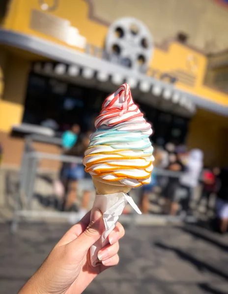 swirled soft-serve ice cream cone in layered colors of red blue and orange