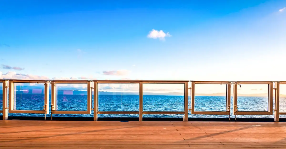 featured image: View from a cruise ship deck overlooking the ocean and clear blue sky, used in an article about first-time cruise mistakes.