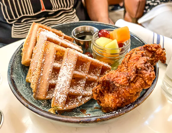 chicken and waffles with a side of fruit