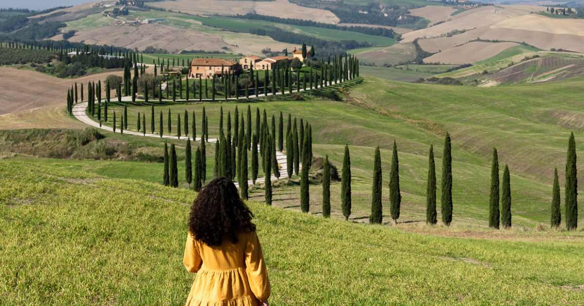 featured blog image without text for italy quotes | kathy in the rolling hills and winding cypress trees of tuscany