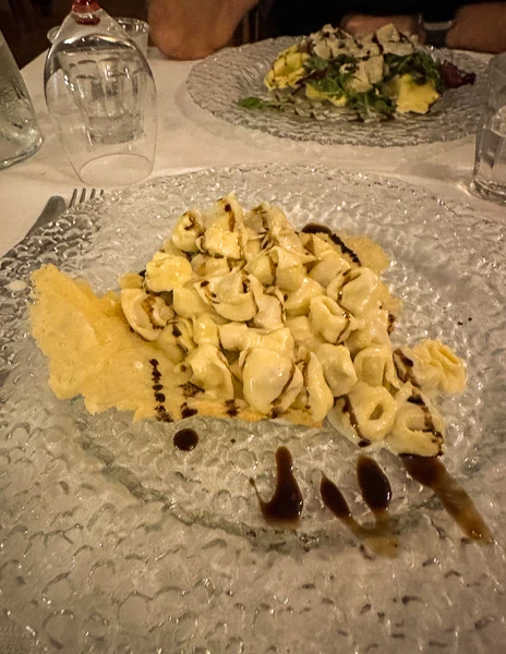 homemade tortelini in a white ragu drizzled with balsamic vinegar