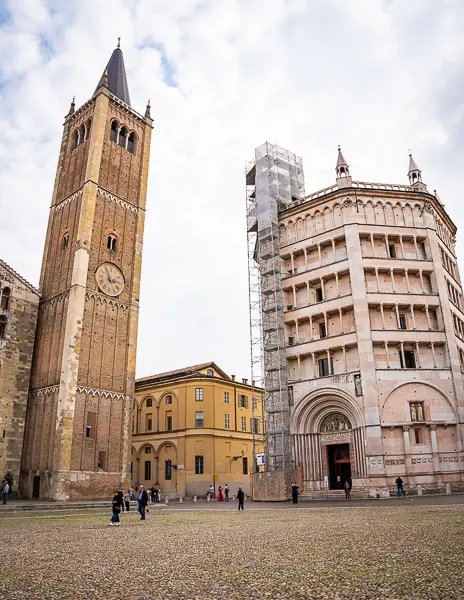 View of Parma’s bell tower and pink marble Baptistery in Piazza Duomo on a cloudy day