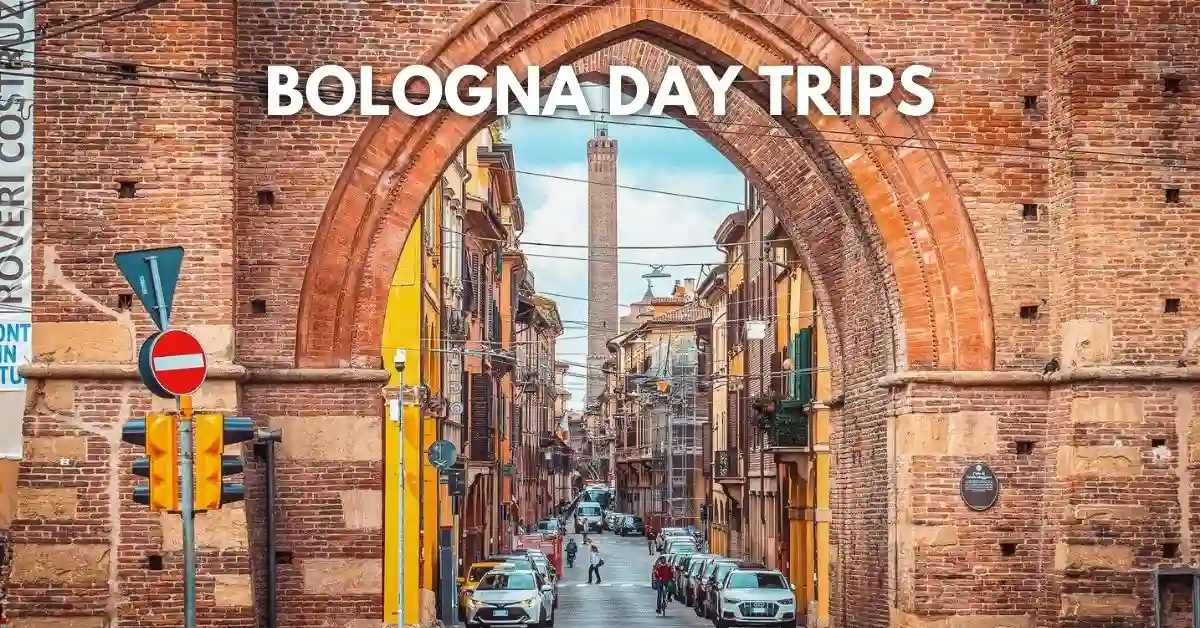 featured image: Street view through Porta San Vitale in Bologna, Italy, with Torre Asinelli visible in the distance and “Bologna Day Trips” text overlayed.