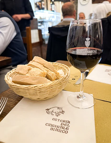 Glass of wine and bread at Osteria del Cinghiale bianco in florence