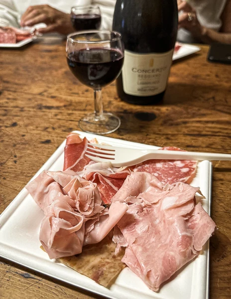 plate of salumi and a glass of lambrusco