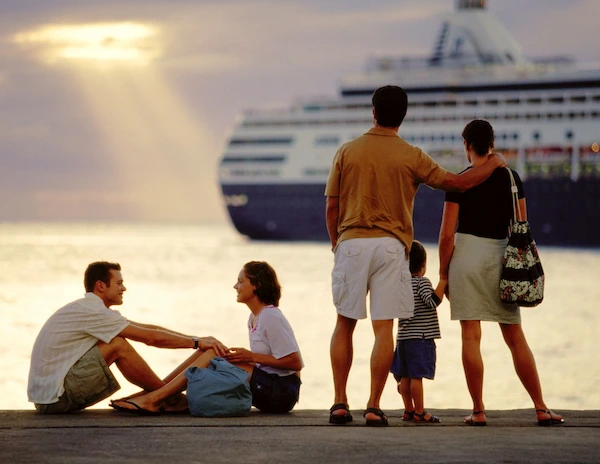 family overlooking the ocean and cruise ship