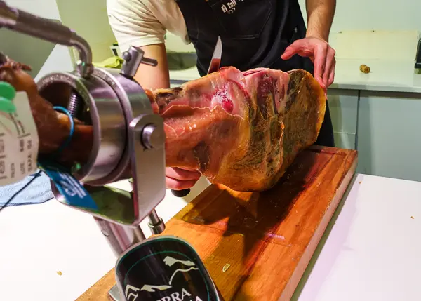 slicing jamon during food tour in girona