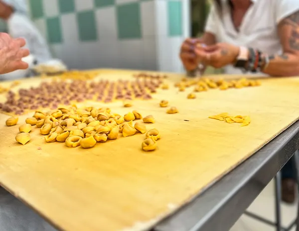 tortellini being made by hand during a food tour in bologna