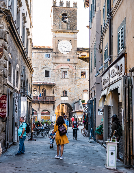 woman in yellow dress strolling down via nazionale in cortona