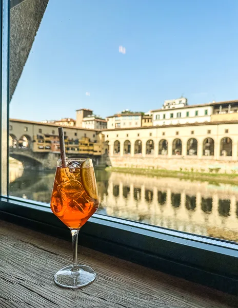 aperol spritz with a view of the river arno and ponte vecchio in florence italy