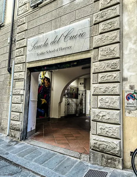 he entrance to the Leather School of Florence (Scuola del Cuoio), showcasing its carved stone facade and inviting doorway leading into the workshop.