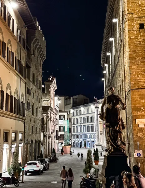 A quiet Florence street at night, framed by historic buildings and softly glowing streetlights, capturing the city's enchanting ambianc