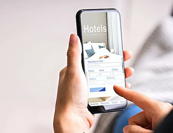 Hands holding a phone with the screen showing a hotel booking