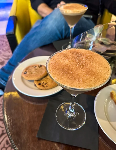 a shaked iced espresso in a martini glass with cookies on the side