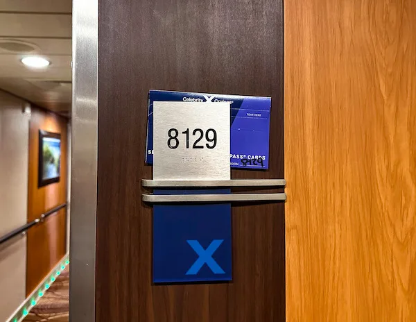 metal sign with 8129 cabin number on the celebrity solstice with envelope tucked behind it.
