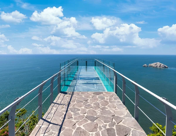 Glass platform at El Faro Lighthouse in Mazatlán extending over the ocean, offering panoramic views of the water and distant islets.
