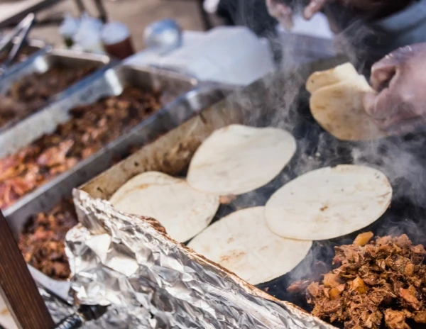 tortillas and meat on griddle