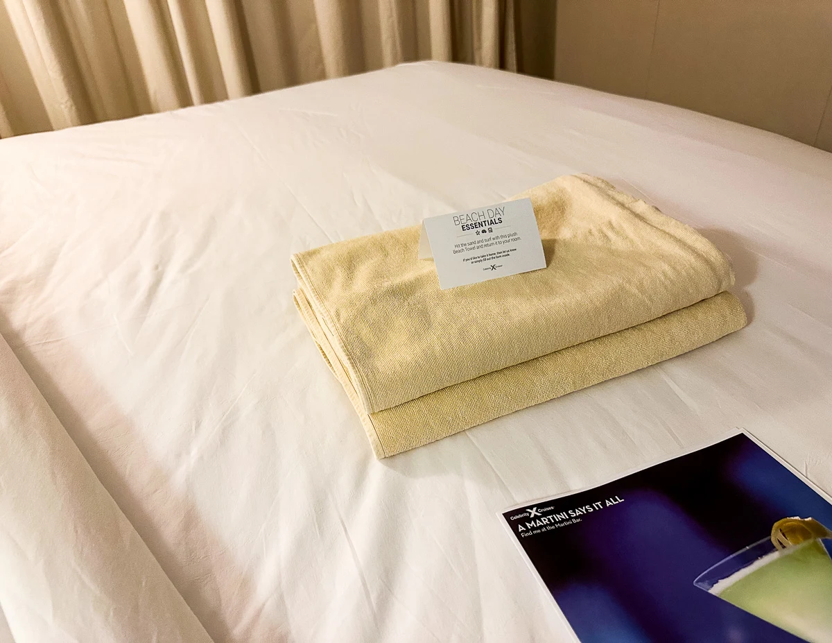 beach towels in cruise ship cabin left at turndown with a sign
