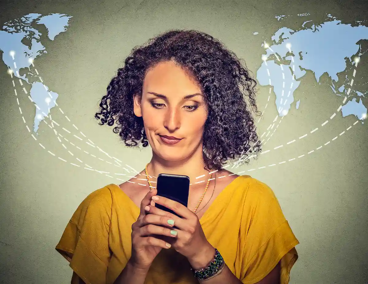woman staring dubiously into her phon with world map above her