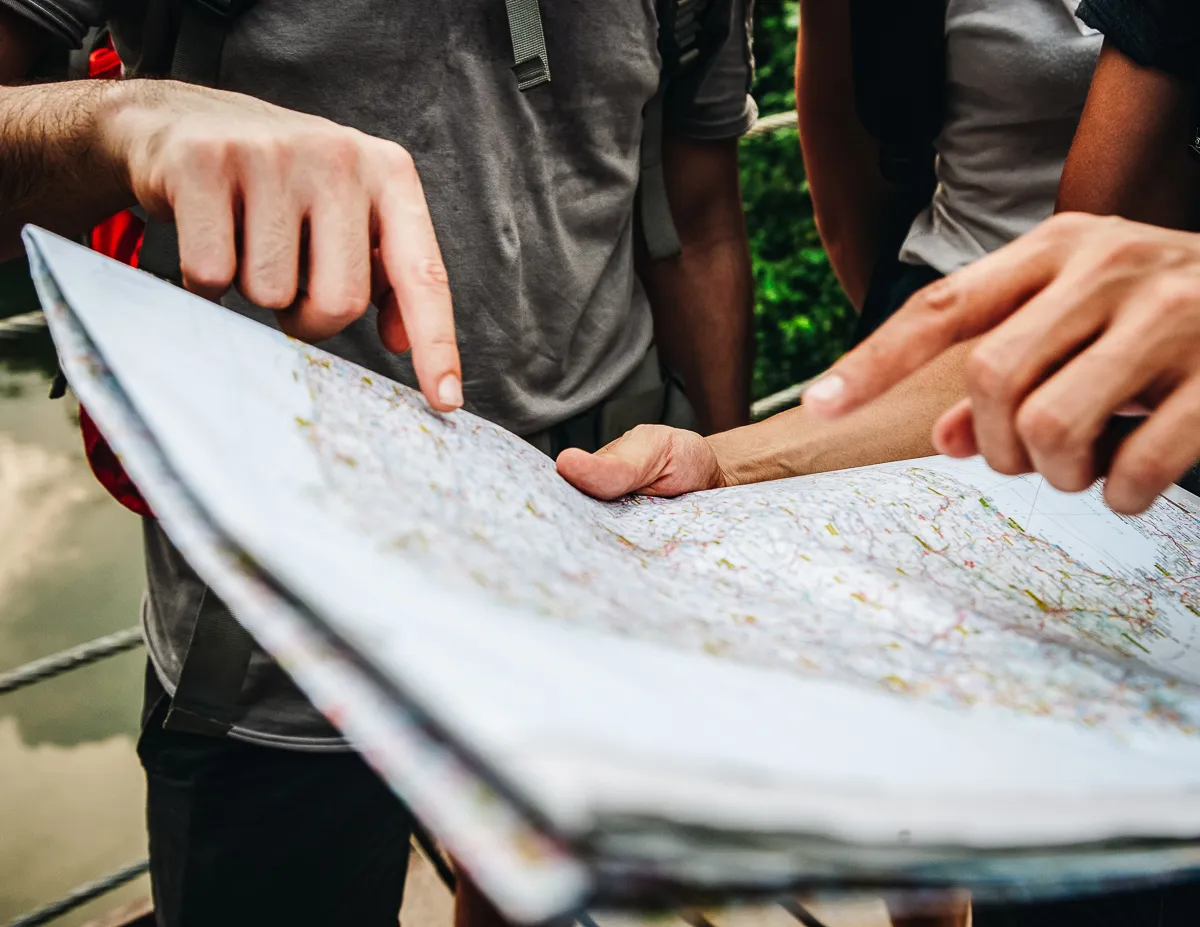 friends overlooking travel paper map