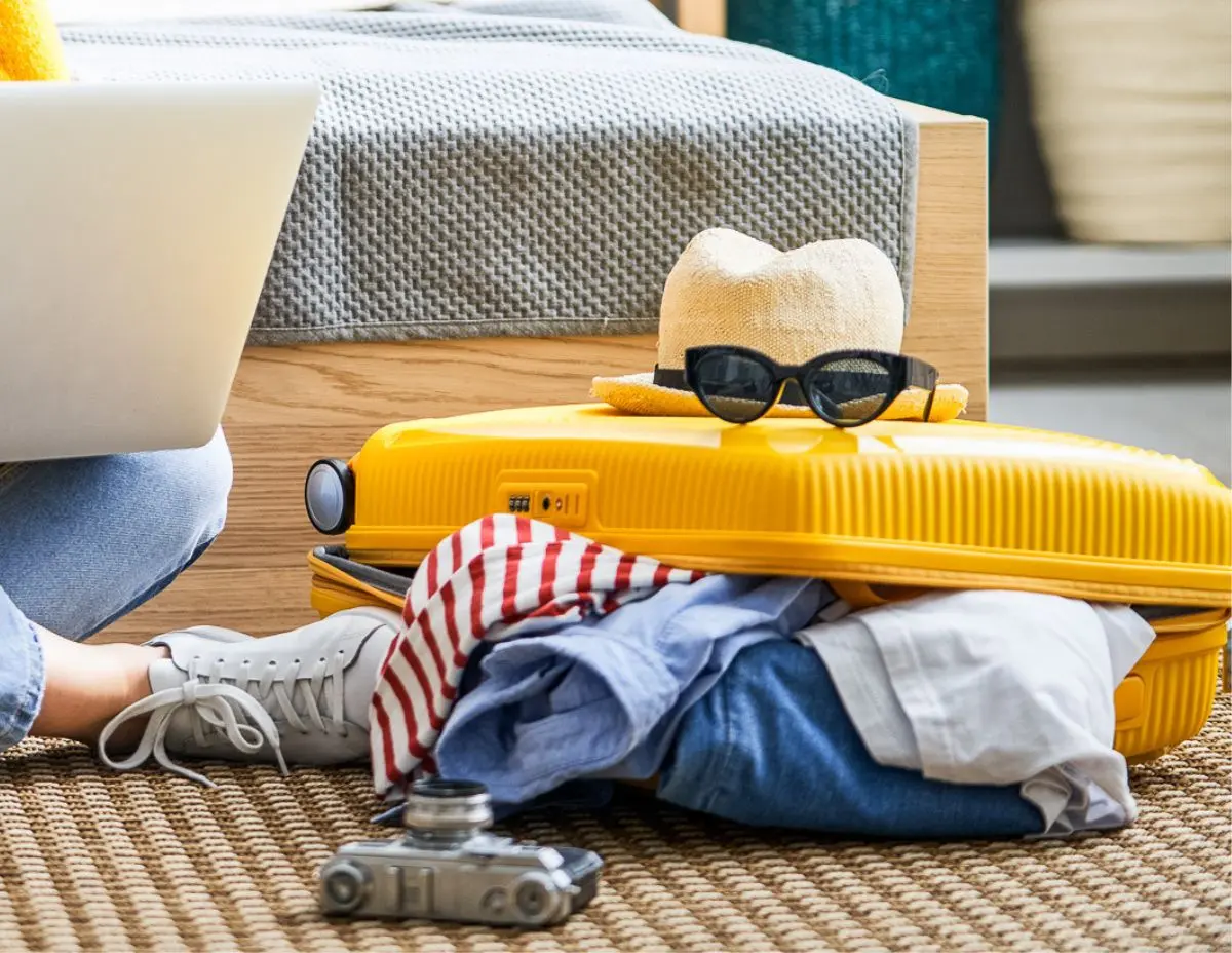 yellow suitcase with clothes coming out of it