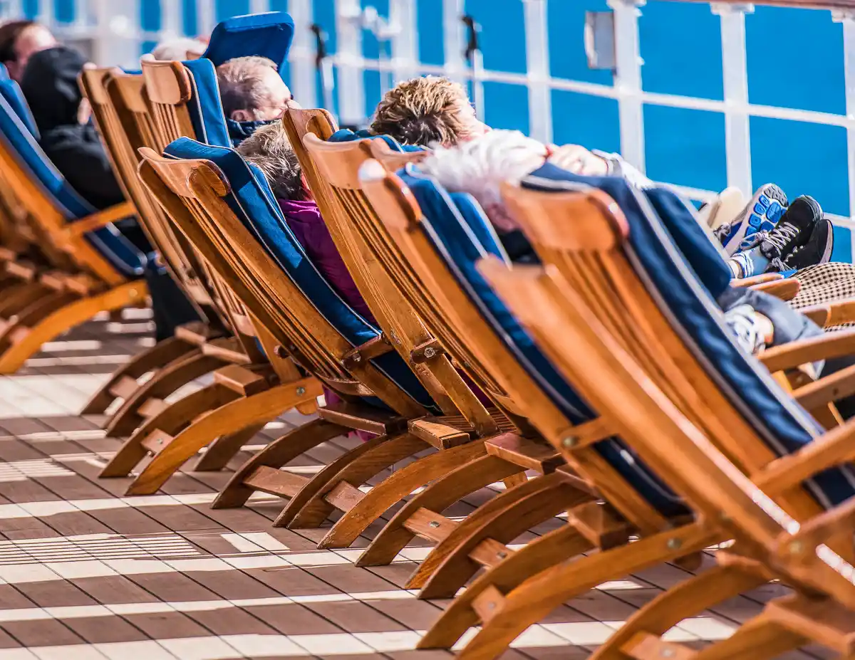 cruisers relaxing on cruise ship deck chairs