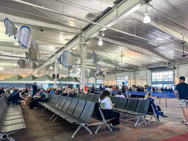 inside san diego cruise terminal rows of blue seating with people waiting