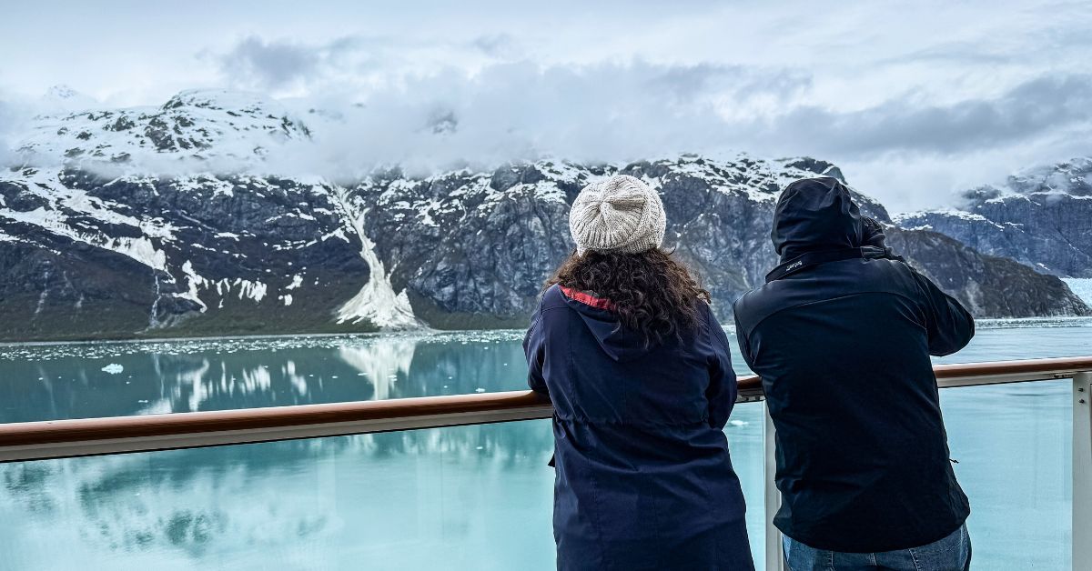 featured image: Cruise passengers on a balcony watching glaciers in Alaska, reflecting key Alaska cruise tips that can impact your trip