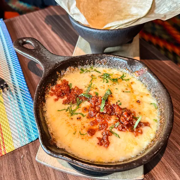 dish of queso fundido from Los Lobos on the Norwegian Encore. This cheesy delight, topped with chorizo and served with warm tortillas