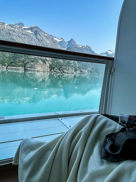 I'm sitting on my balcony with the extra blanket while cruising Glacier Bay.