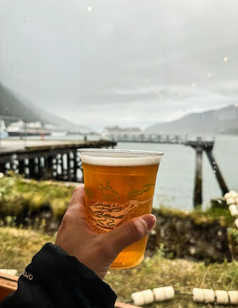 Holding a beer with a view of the waterfront and a pier in Juneau