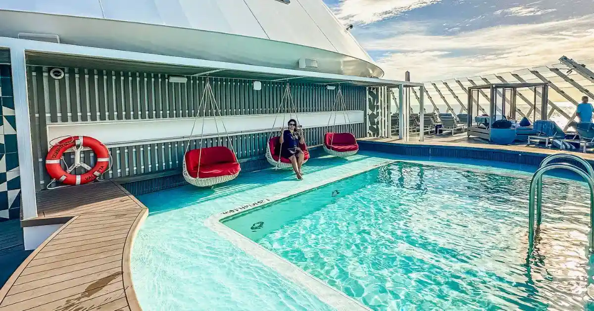 featured blog image of celebrity beyond review the retreat experience | kathy sitting on a red chair at the retreat pool