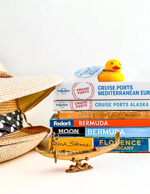 cruise duck sitting on travel planning books 