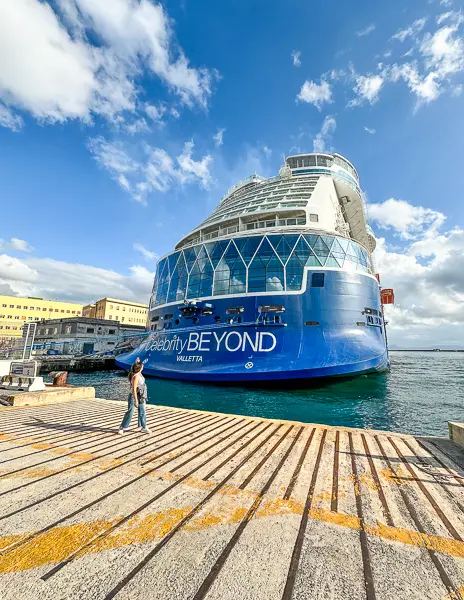 kathy standing in front of the celebrity beyond aft in naples cruise port