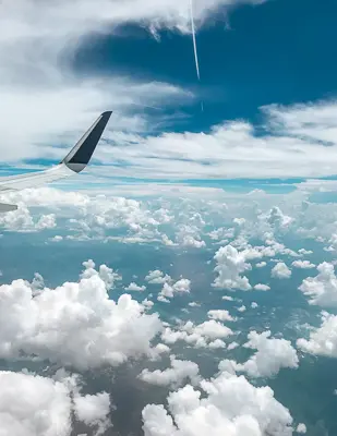 plane wing about blue skies and clouds