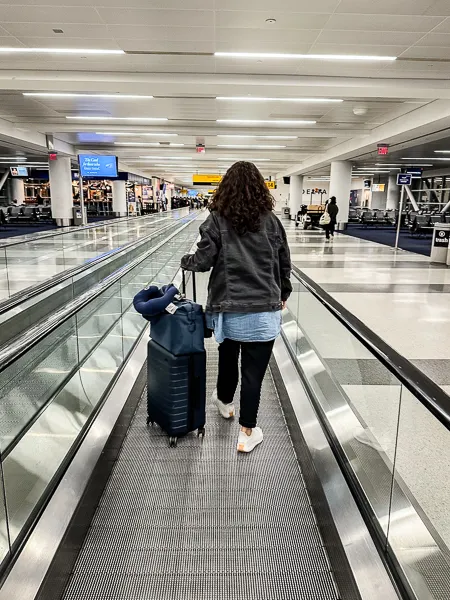 kathy pulling away luggage through the airport terminal