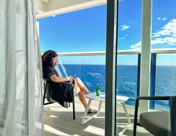 kathy sitting on the sky suite balcony on celebrity beyond ship reading