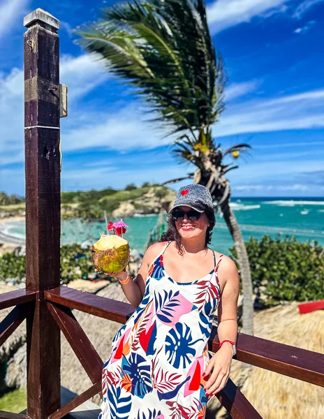 kathy holding onto a coconut in Puerto Plata port wearing her caribbean must-have items she packed