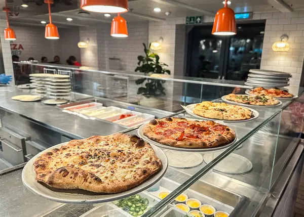 pizzas lined up out of the oven on the counter at The Pizza Palace on Scarlet Lady