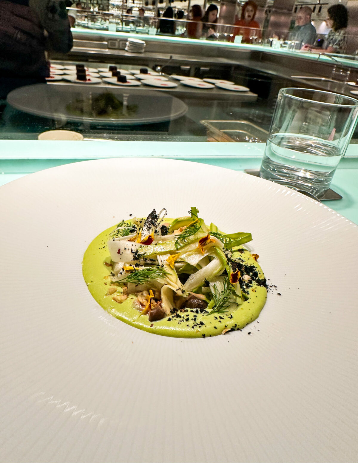 A gourmet asparagus panna cotta dish from The Test Kitchen on Virgin Voyages, artfully plated with delicate garnishes.