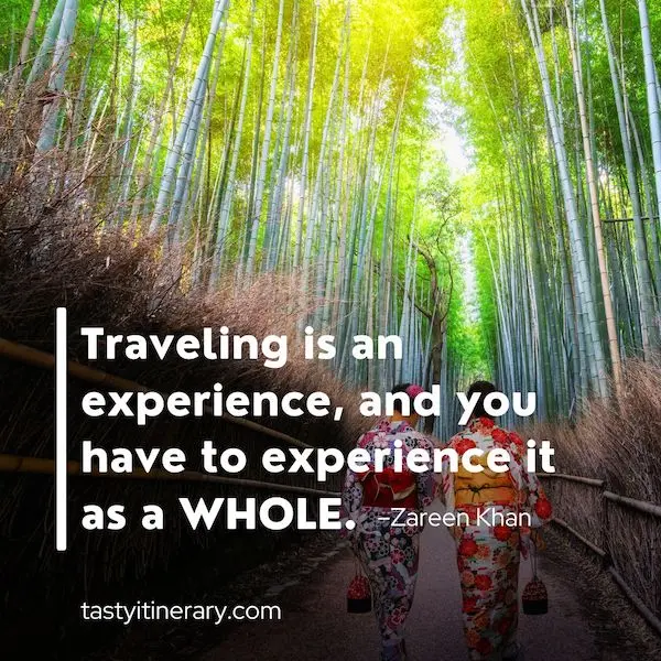 The image features a scenic bamboo forest path with two people walking away from the camera, dressed in traditional kimono. Overlaying the image is the quote, “Traveling is an experience, and you have to experience it as a WHOLE.” - Zareen Kha