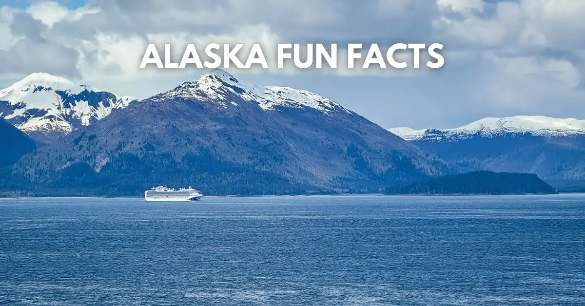 featured image: Cruise ship sailing in front of snow-capped mountains in Alaska under a cloudy sky, with text overlay that reads “Alaska Fun Facts.”